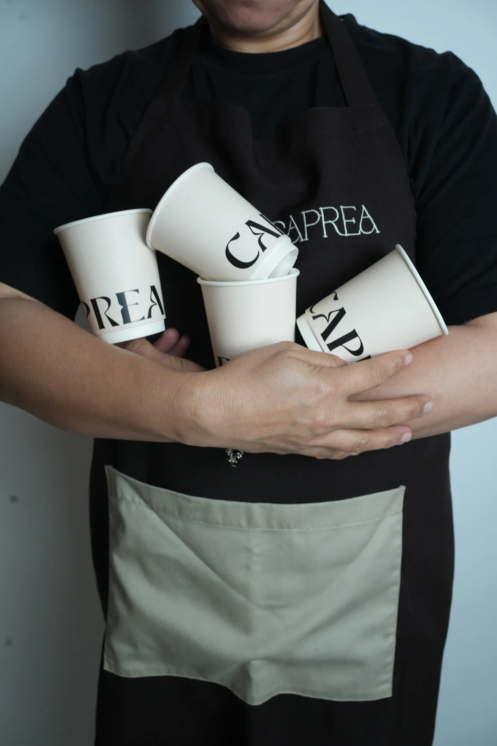 Caprea barista holding branded cups